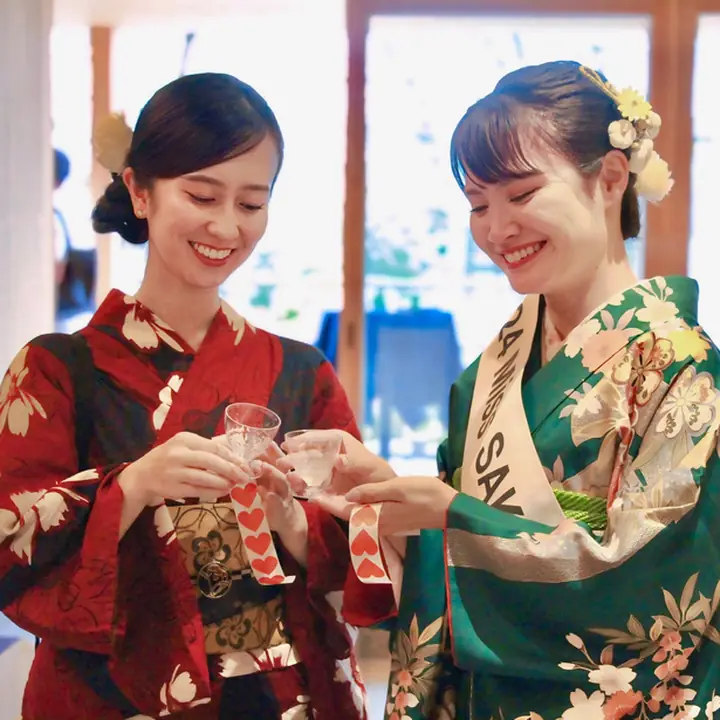 着物姿の2人が猪口で乾杯している様子